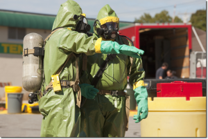 Picture of two men in hazmat suits discussing procedure.