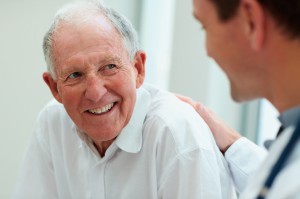 Image of a happy old man having a casual talk with a doctor.