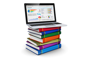Image of a laptop on top of a stack of books.